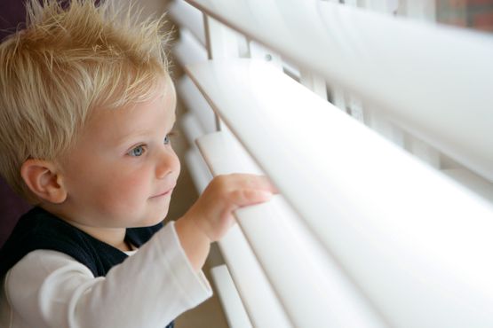 Child looking through shutter